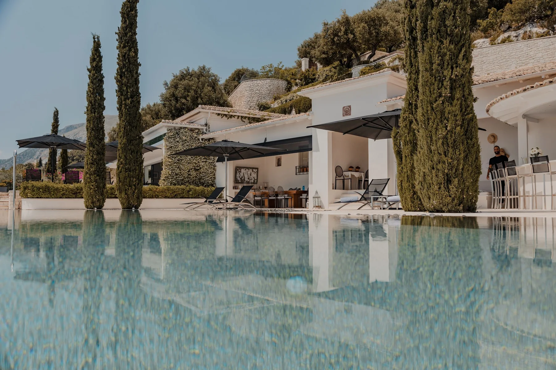 The infinity pool and cypress trees at Ultima Corfu, Greece