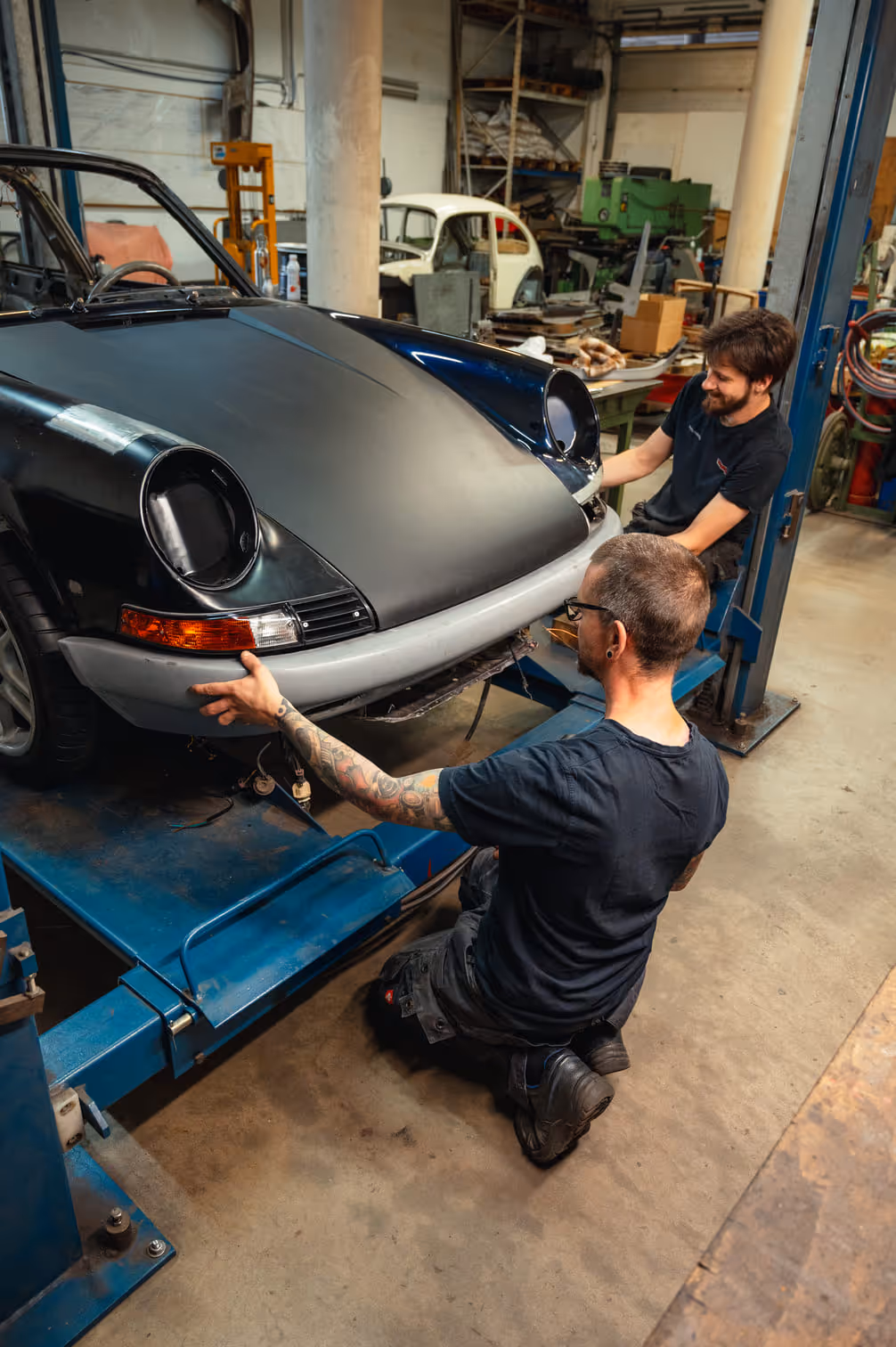 Two handyman working on a Porsche restomod