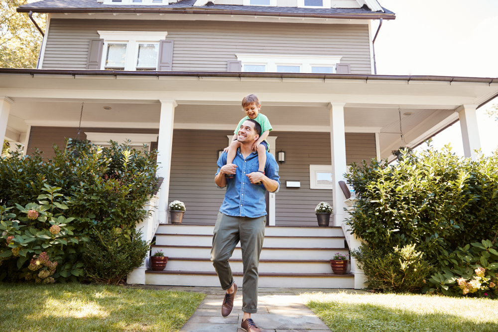 Father and son in front of house.