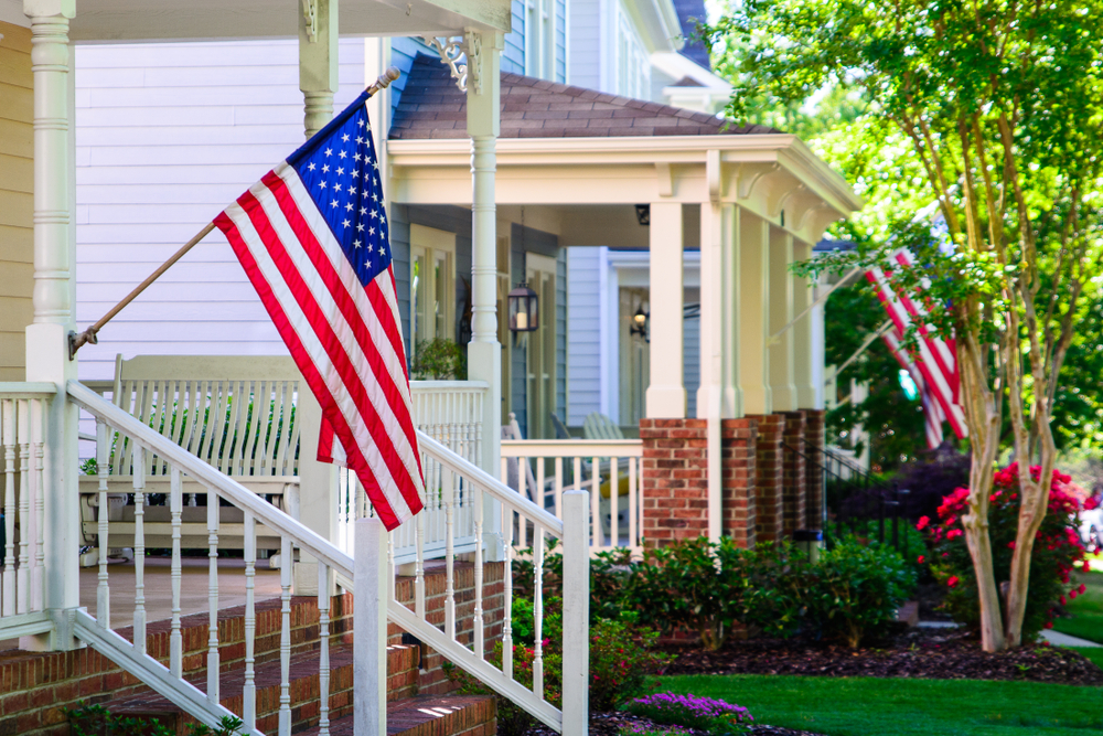 American flags on homes in quaint neighborhood.