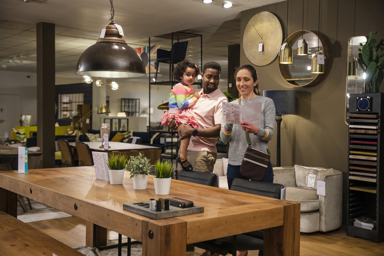 Couple and child in furniture store selecting items.