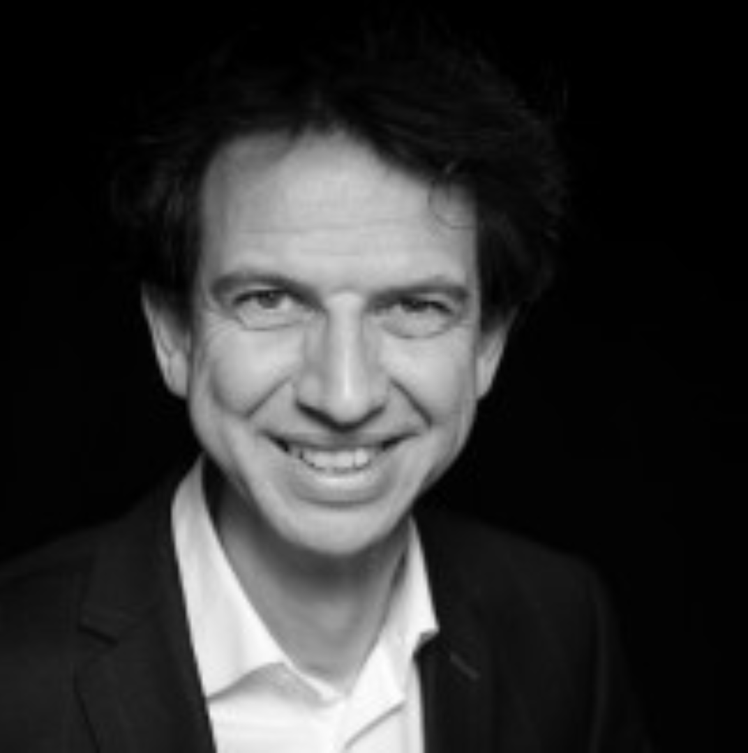 Zwart-wit portret van lachende man in pak met gekruld haar