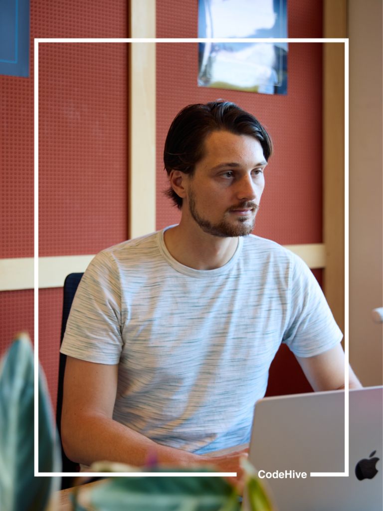 Tim werkt aan een bureau in het kantoor van CodeHive