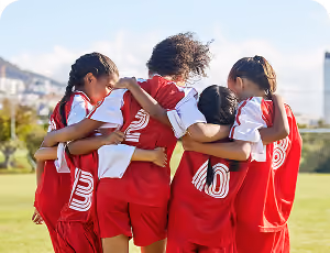 Girl's soccer team hugging.