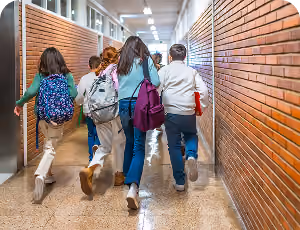 Elementary school students running down a hallway.