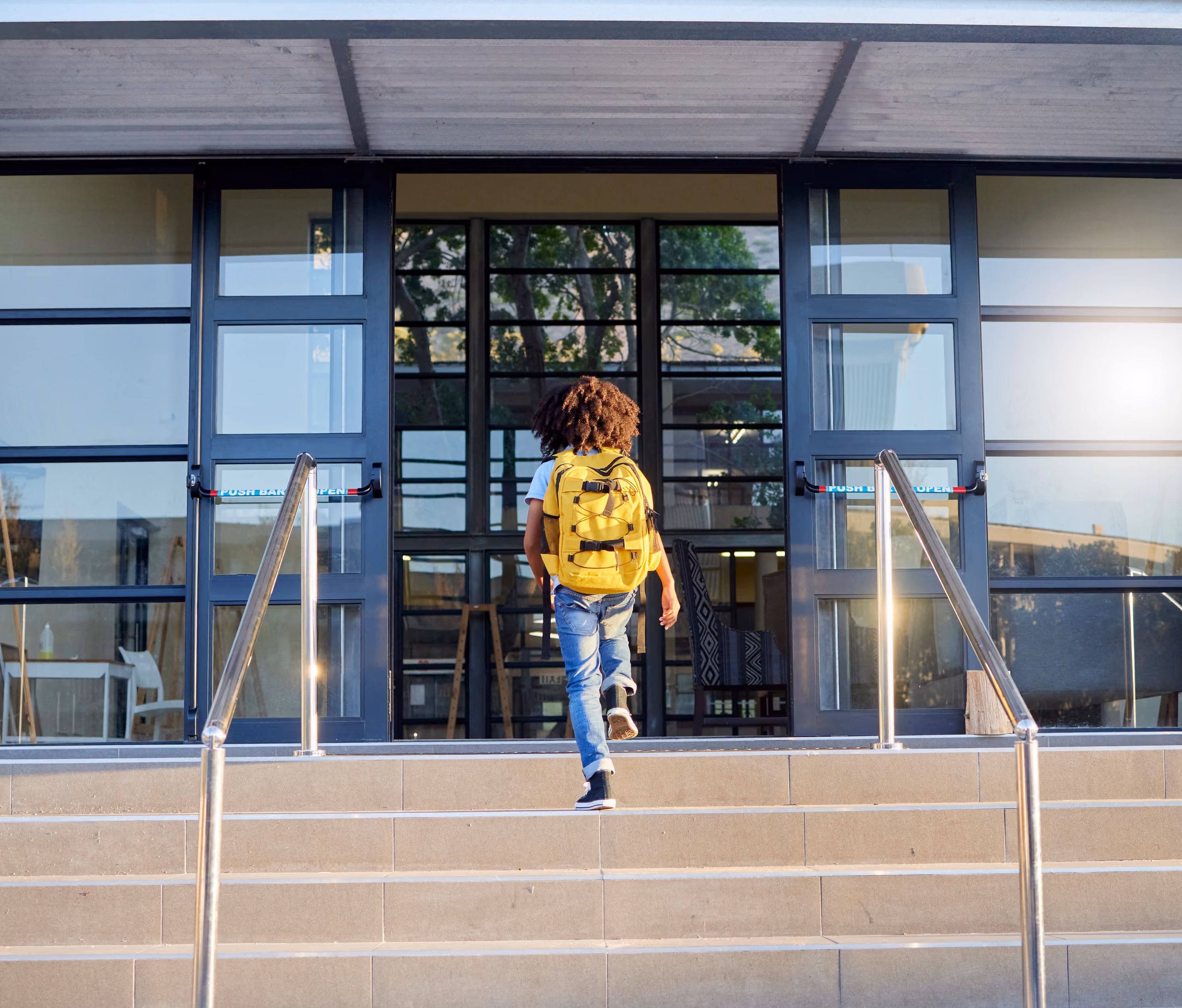 a student climbing up the stairs of a school