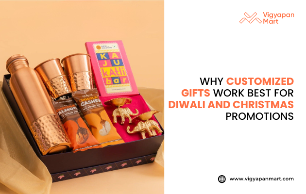 Festive gift hamper with copper bottles, dry fruits, chocolate, and golden decorative elephants, designed for Diwali and Christmas corporate gifting. Promotional banner by Vigyapan Mart with text: "Why customized gifts work best for Diwali and Christmas promotions." Website: www.vigyapanmart.com