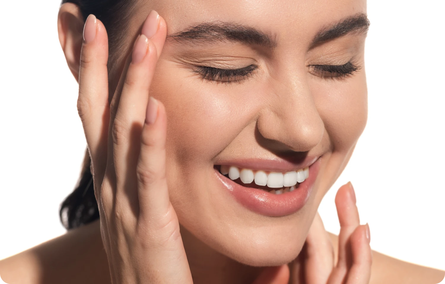 Smiling woman with glowing skin after IPL photofacial treatment, touching face with closed eyes
