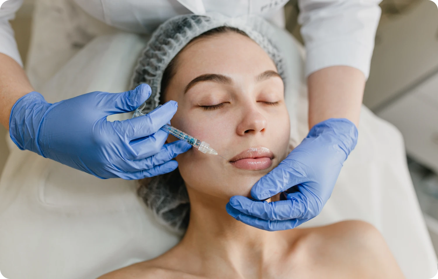 Happy woman receiving Botox treatment for youthful skin at a clinic.