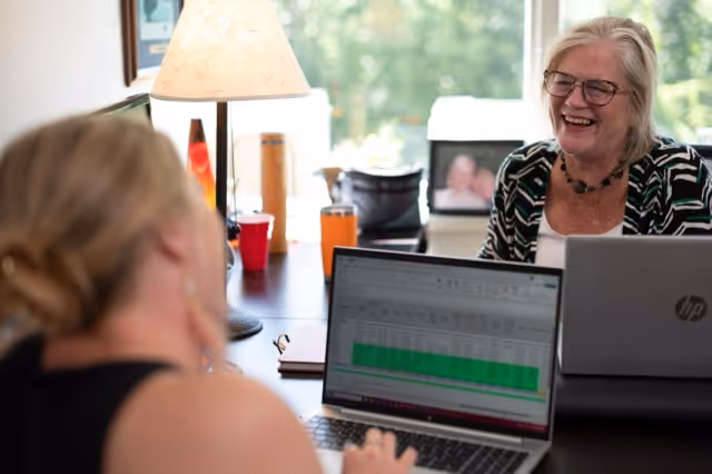 Smiling Alteris employees working on computers