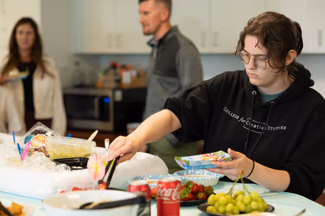 Alteris employees  choosing food from plate