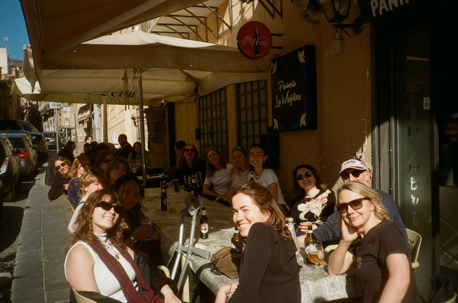 Members of Haverstock Architect's team sat around a table in a sunny street terrace in Palermo.