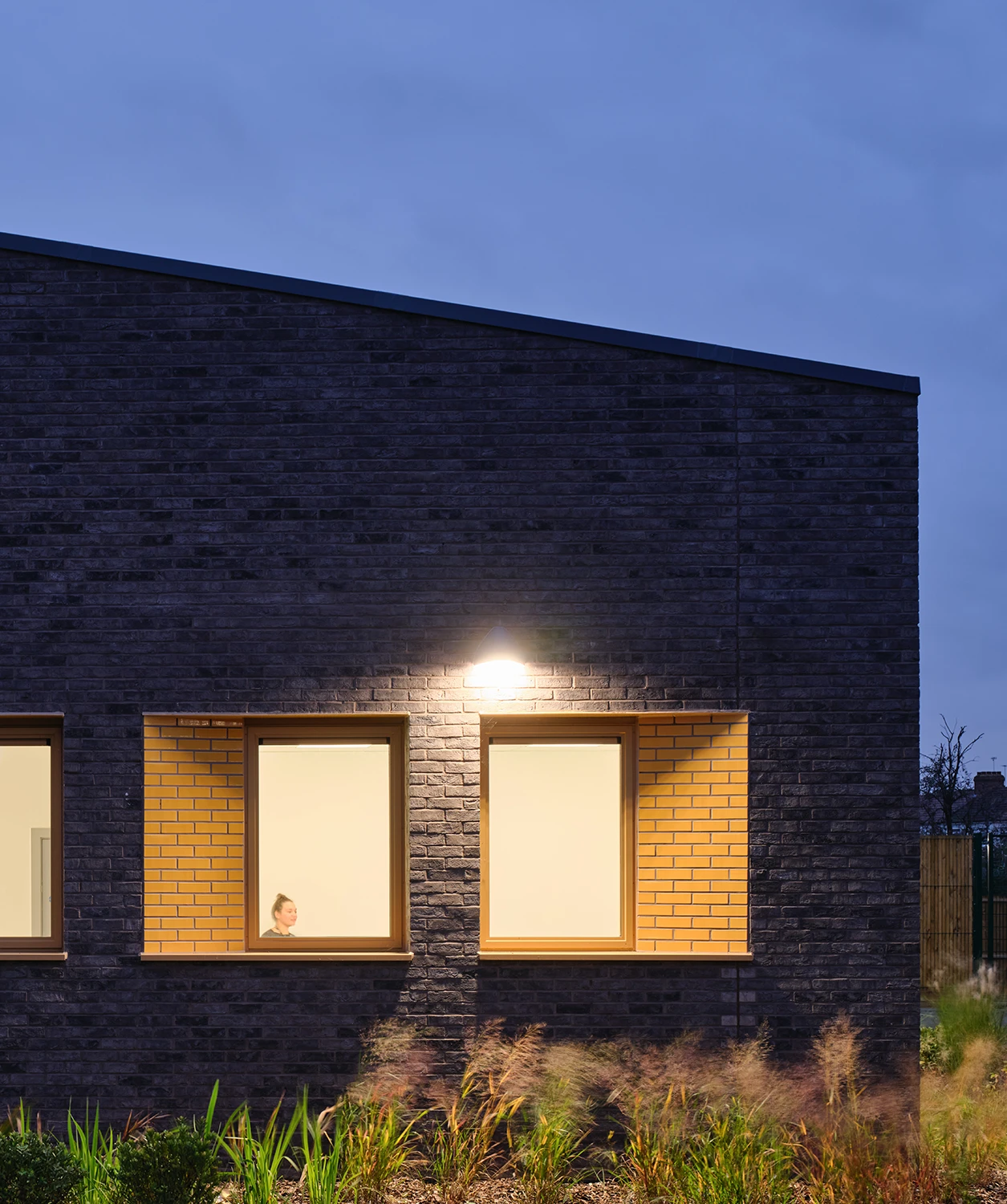 Front elevation of school's brick building at dusk.