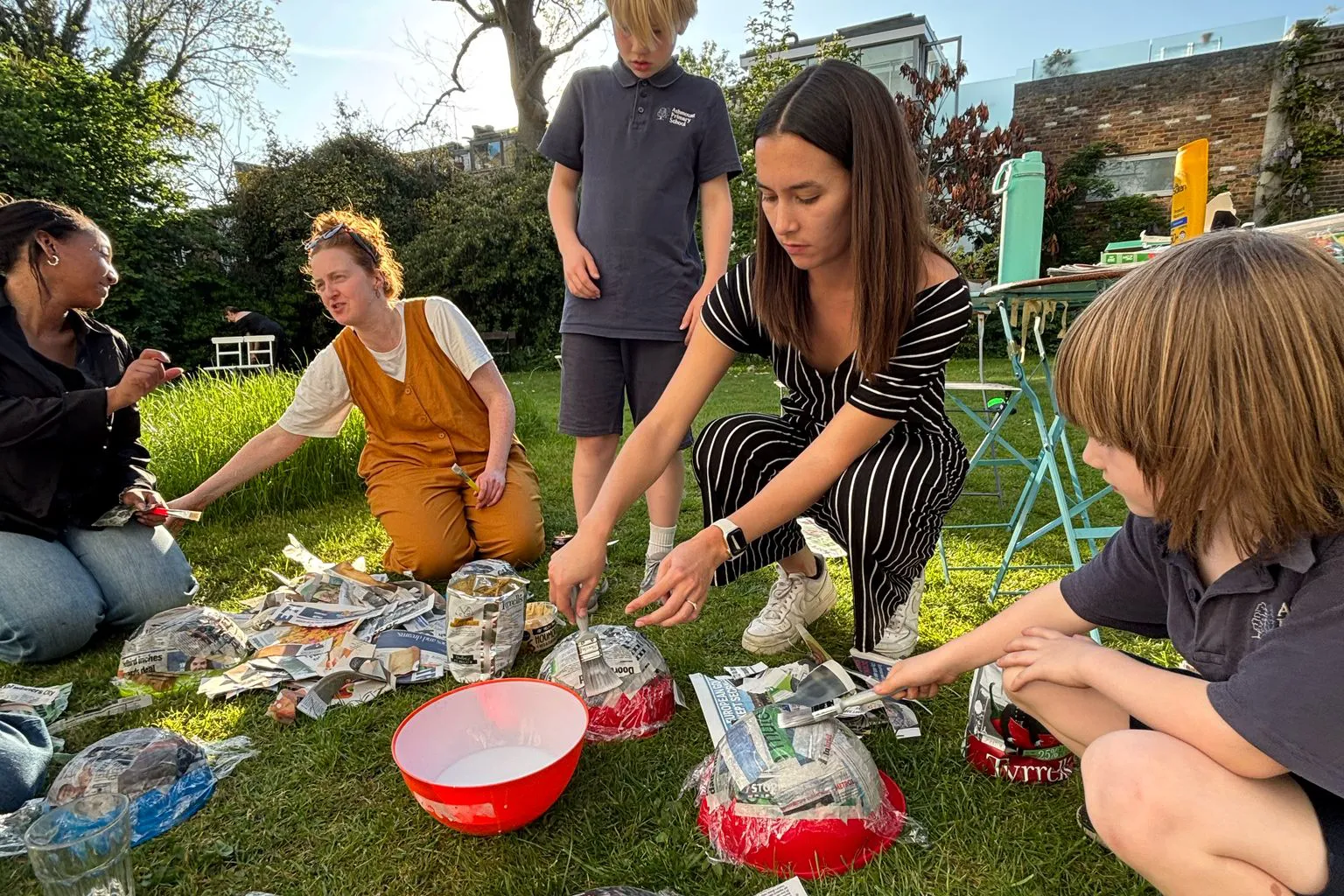 Members of Haverstock Architects' team making papier-mâché objects with school children.