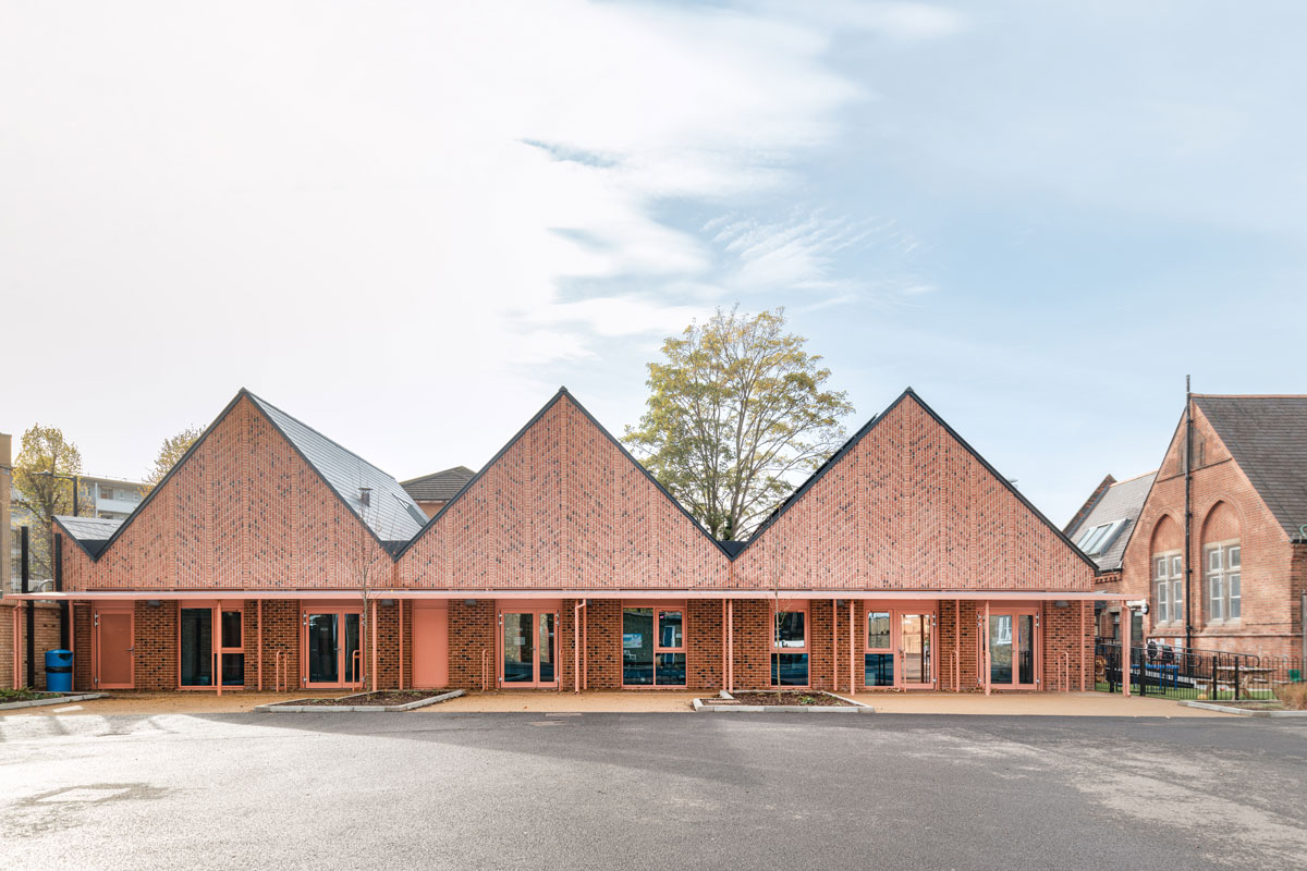 A photo of the school's new teaching block, with a trio of terraced pitched roofs, clad in brick slips.