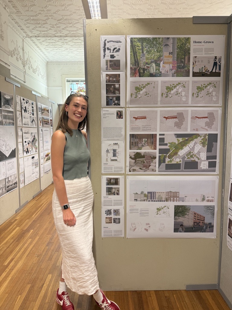 Ella stood in front of her work displayed on a wall.