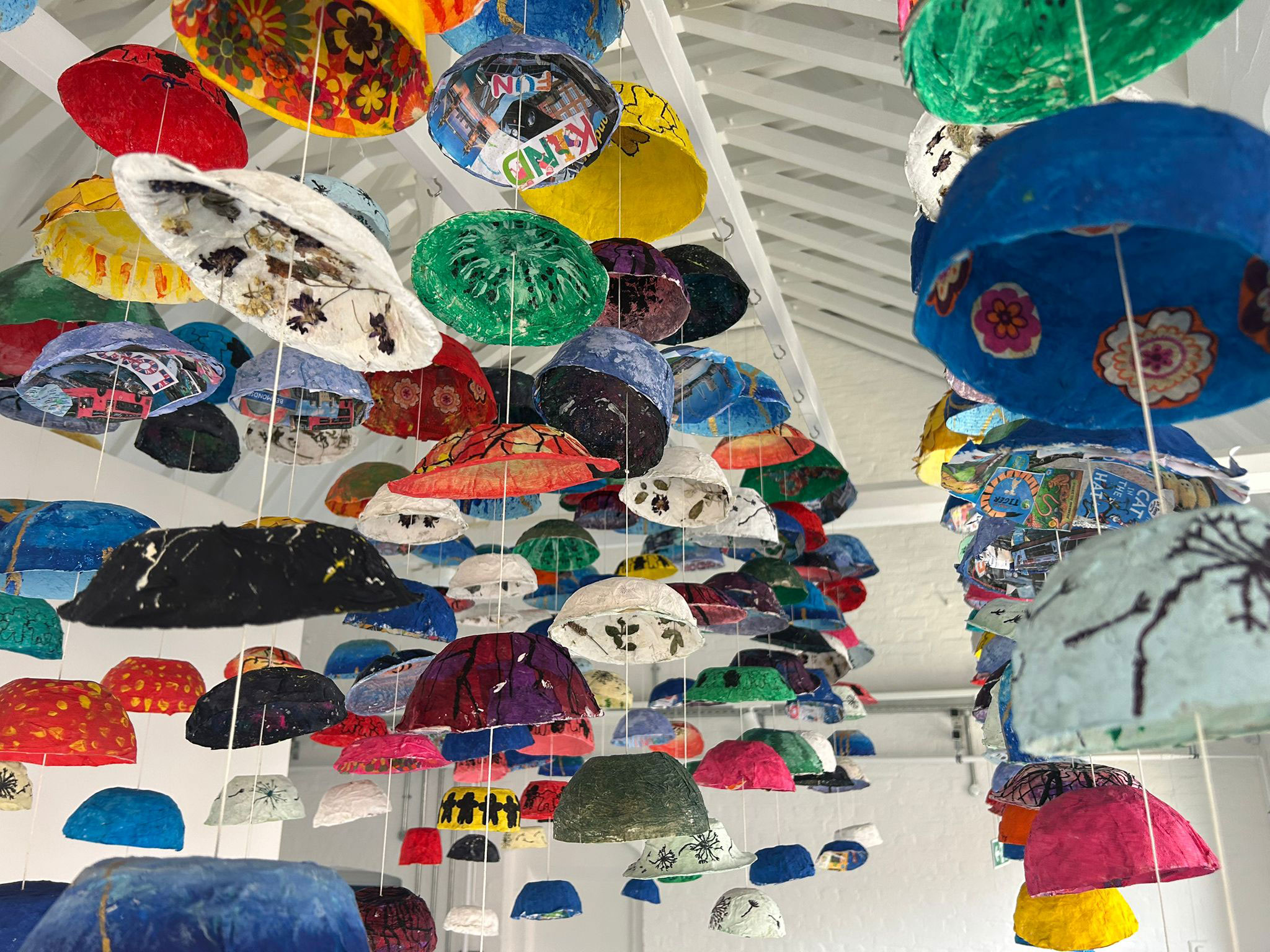 The multicoloured artwork hanging from the rafters. Many different designs
by the students can be seen including, a watermelon, trees, pressed flowers and collage.