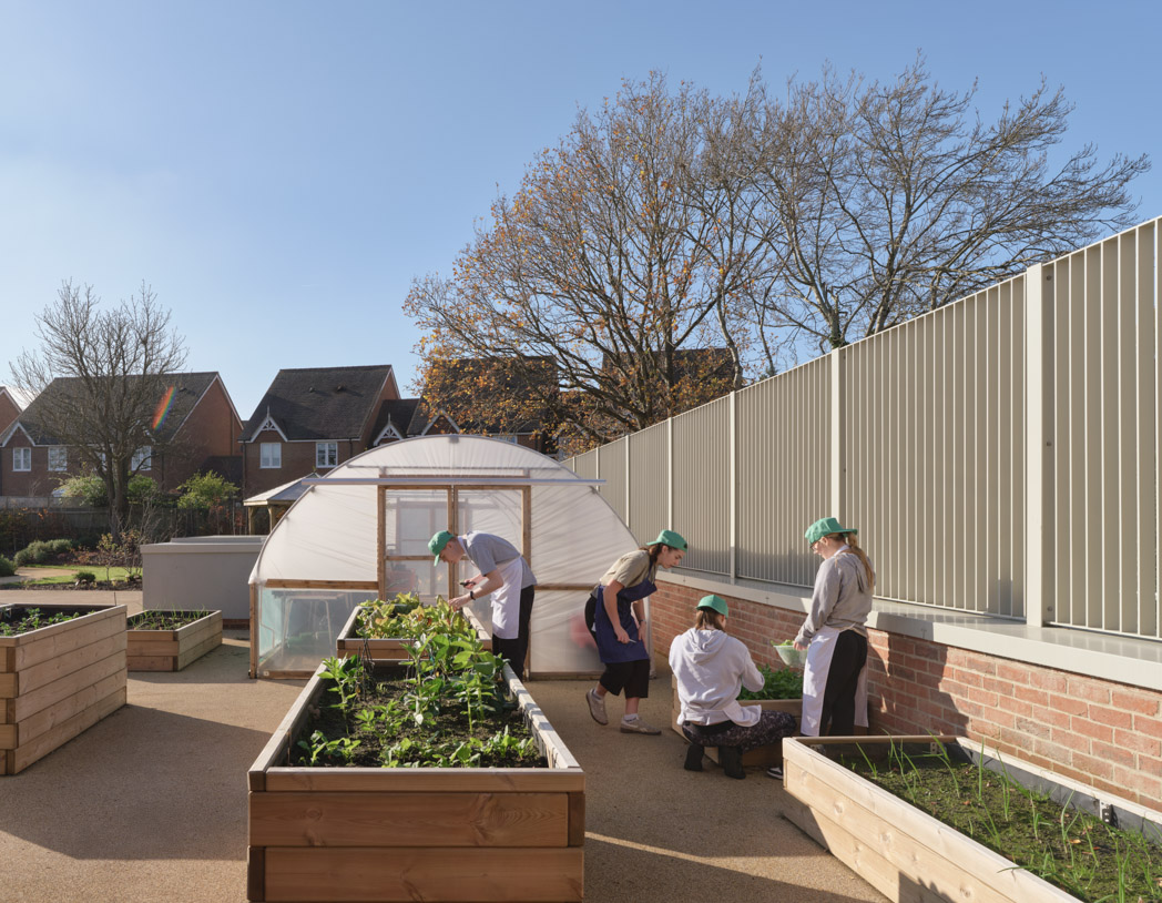 A photo of the Greenhouse space at the College. Students garden in a planter
outside the polytunnel, supporting their horticultural studies. Green vegetation springs
from the surrounding planters.