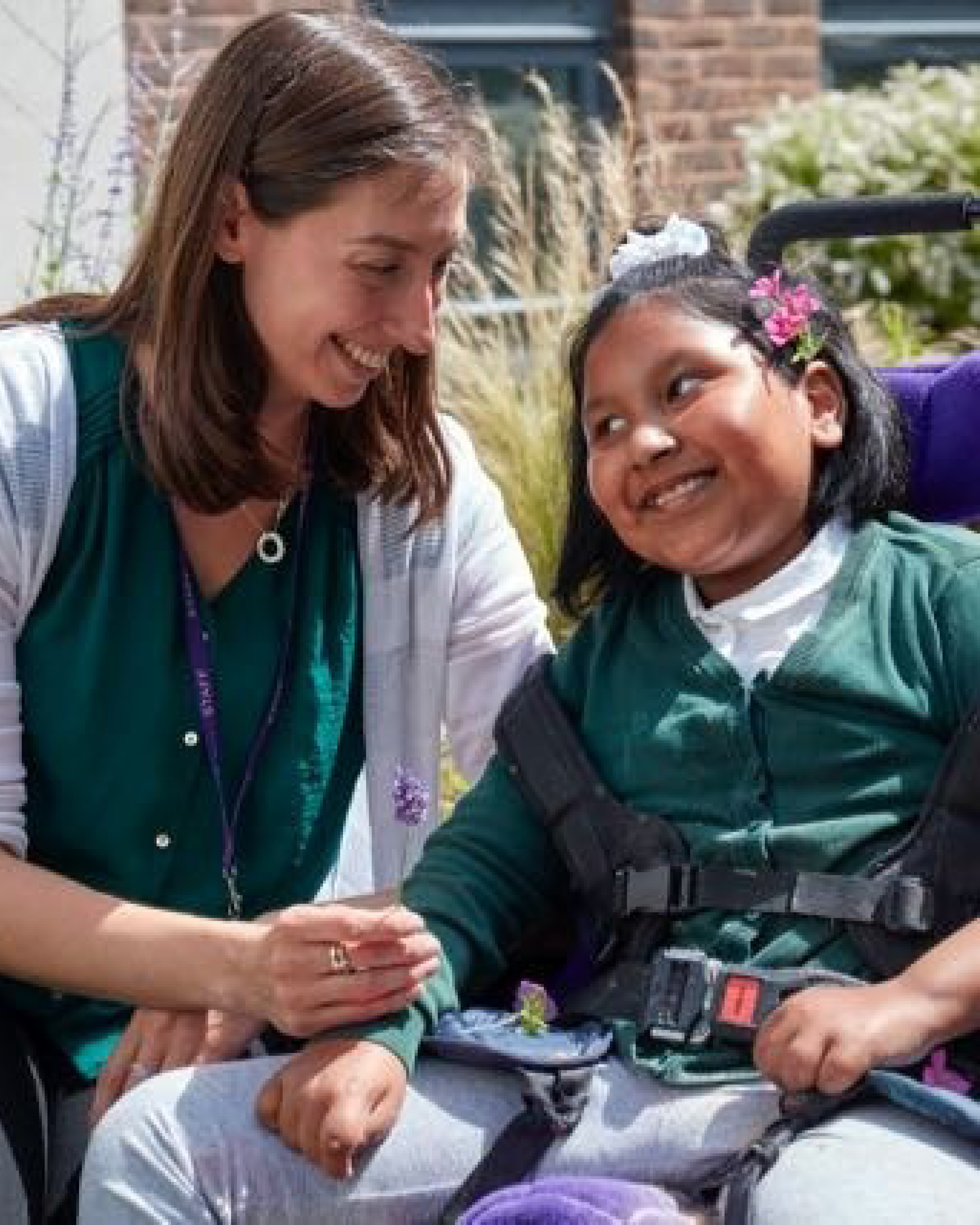 A photo of Lara with a student. They smile facing each other. The photo has a blue overlay with white text reading ‘Showcasing Inspiring Women in the built environment, education and inclusive design’