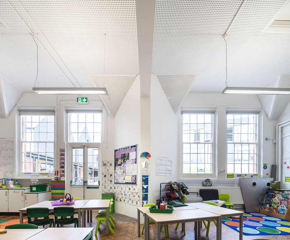 The inside of a retrofitted classroom, the original beams have been repainted white to create a bright, inviting room.