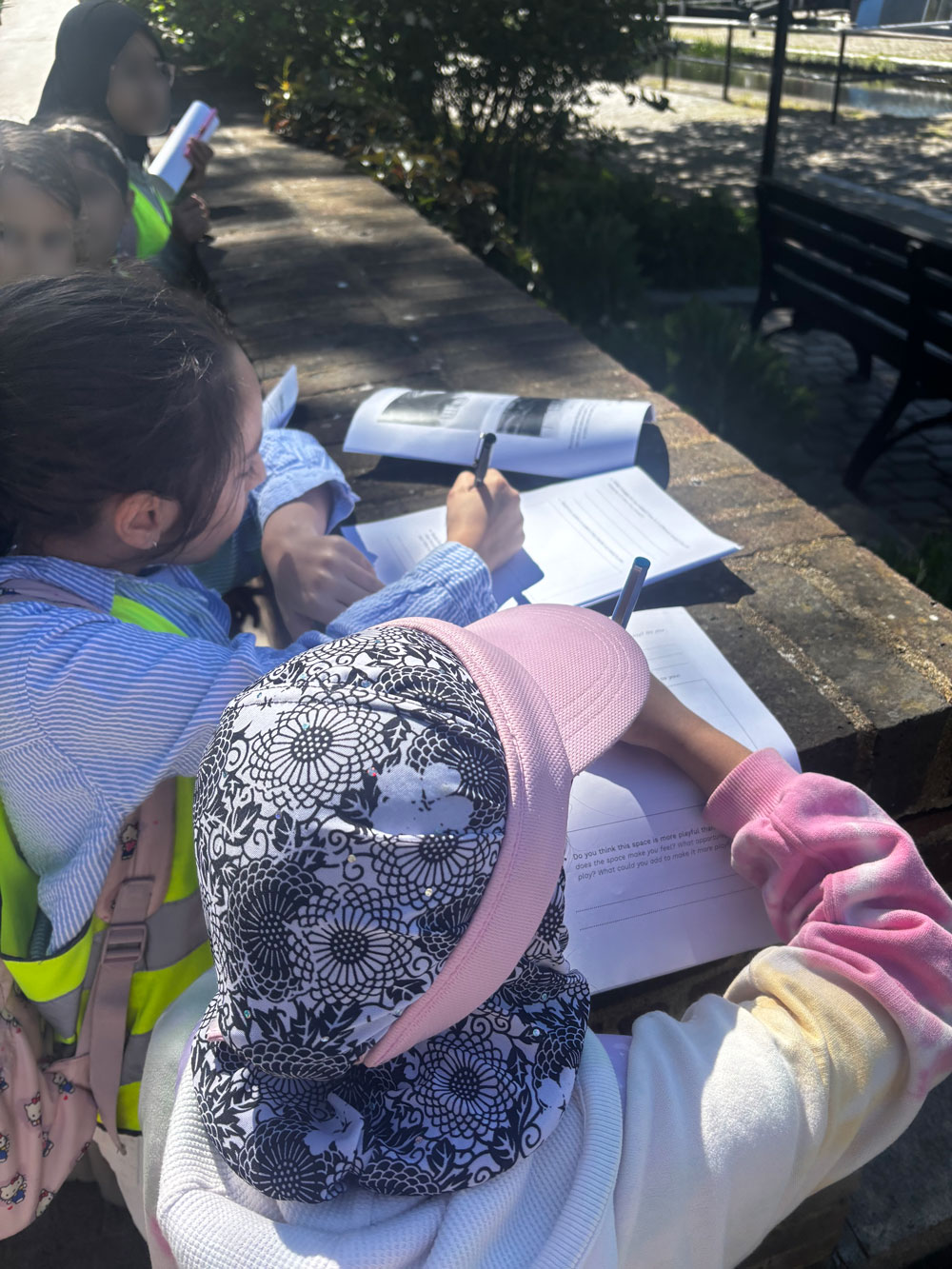 Students completing their worksheets on the brick wall by Regents Canal