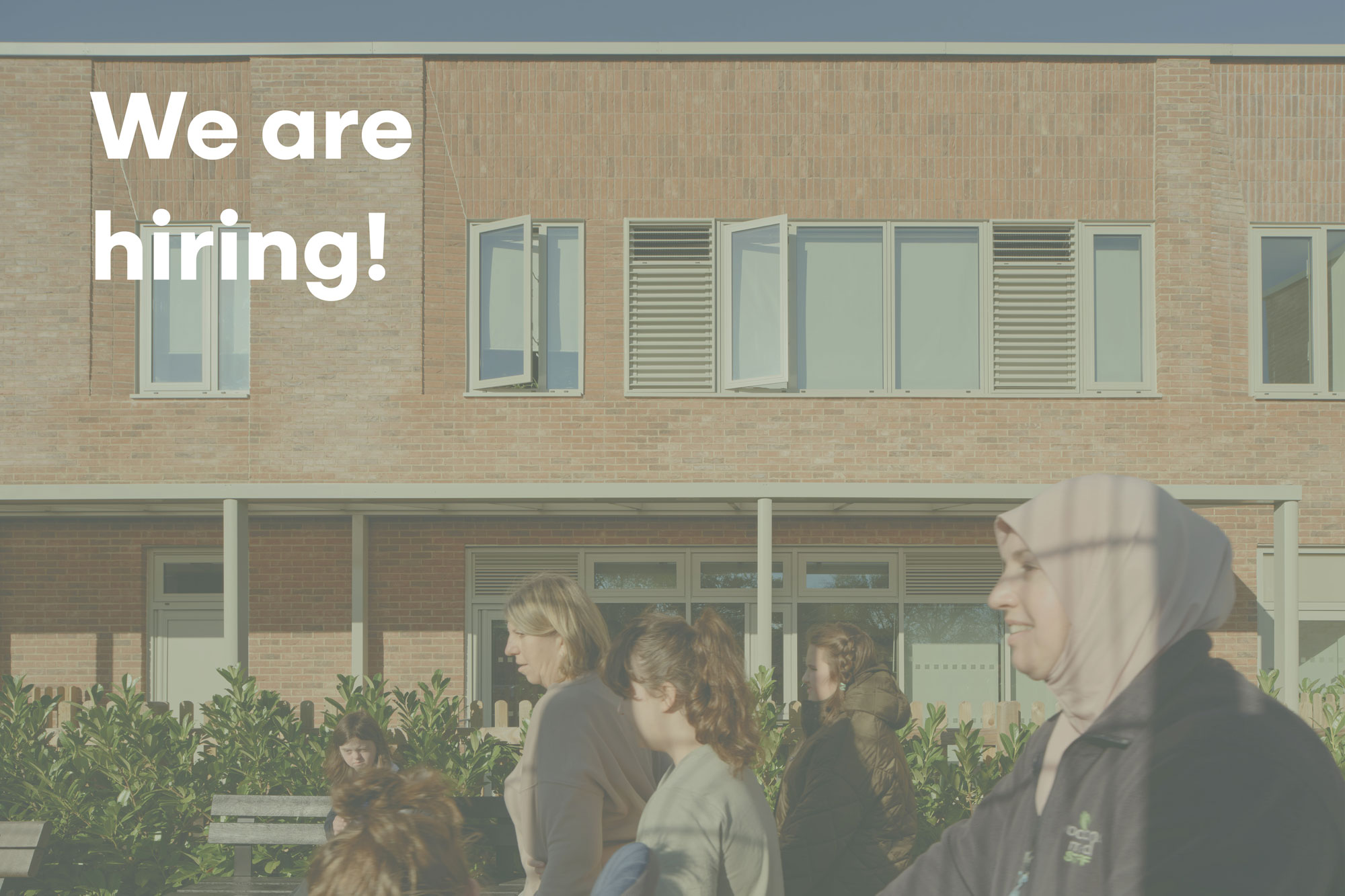 A photo of the façade of Woodlands Meed College, with an overlay of text reading 'We are hiring' 