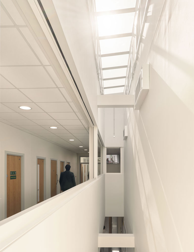 The atrium from the first floor, light shines into the circulation spaces below.