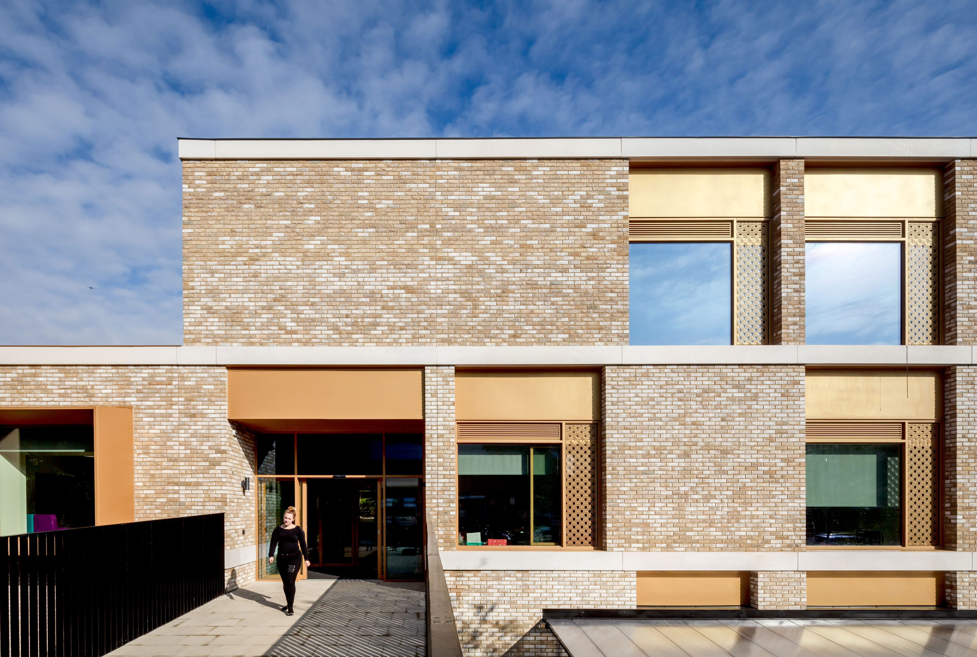 External view of person exiting the brick clad school building.