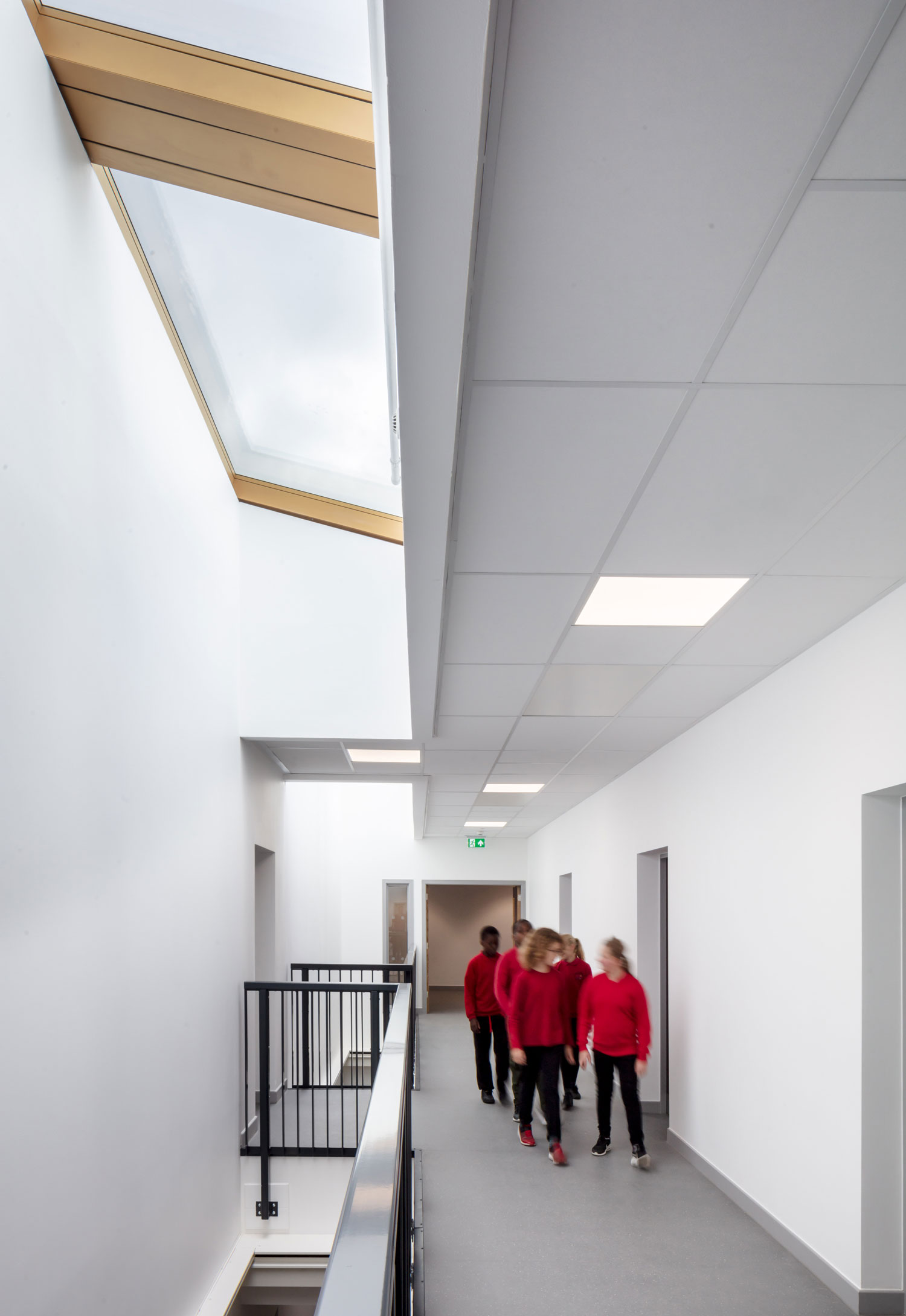 Students sitting on timber clad amphitheatre style seating with generous window behind.