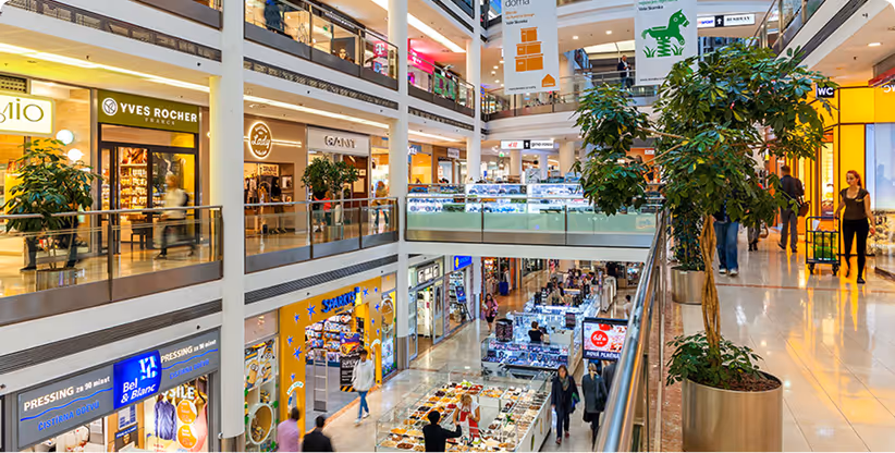 An image of a brightly lit shopping mall at dusk.