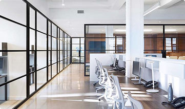 A modern office with a framed glass wall