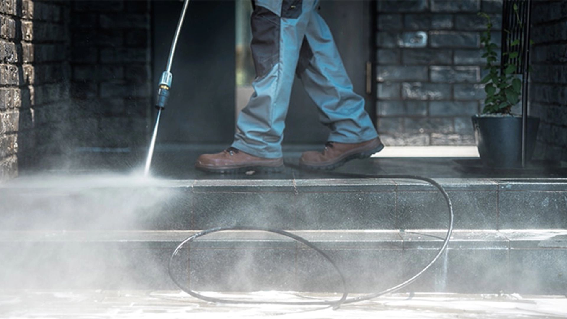worker power washing outside steps
