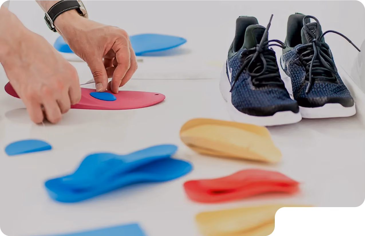 A male doctor puts custom orthotics into a pair of shoes for a patient in Beverly Hills