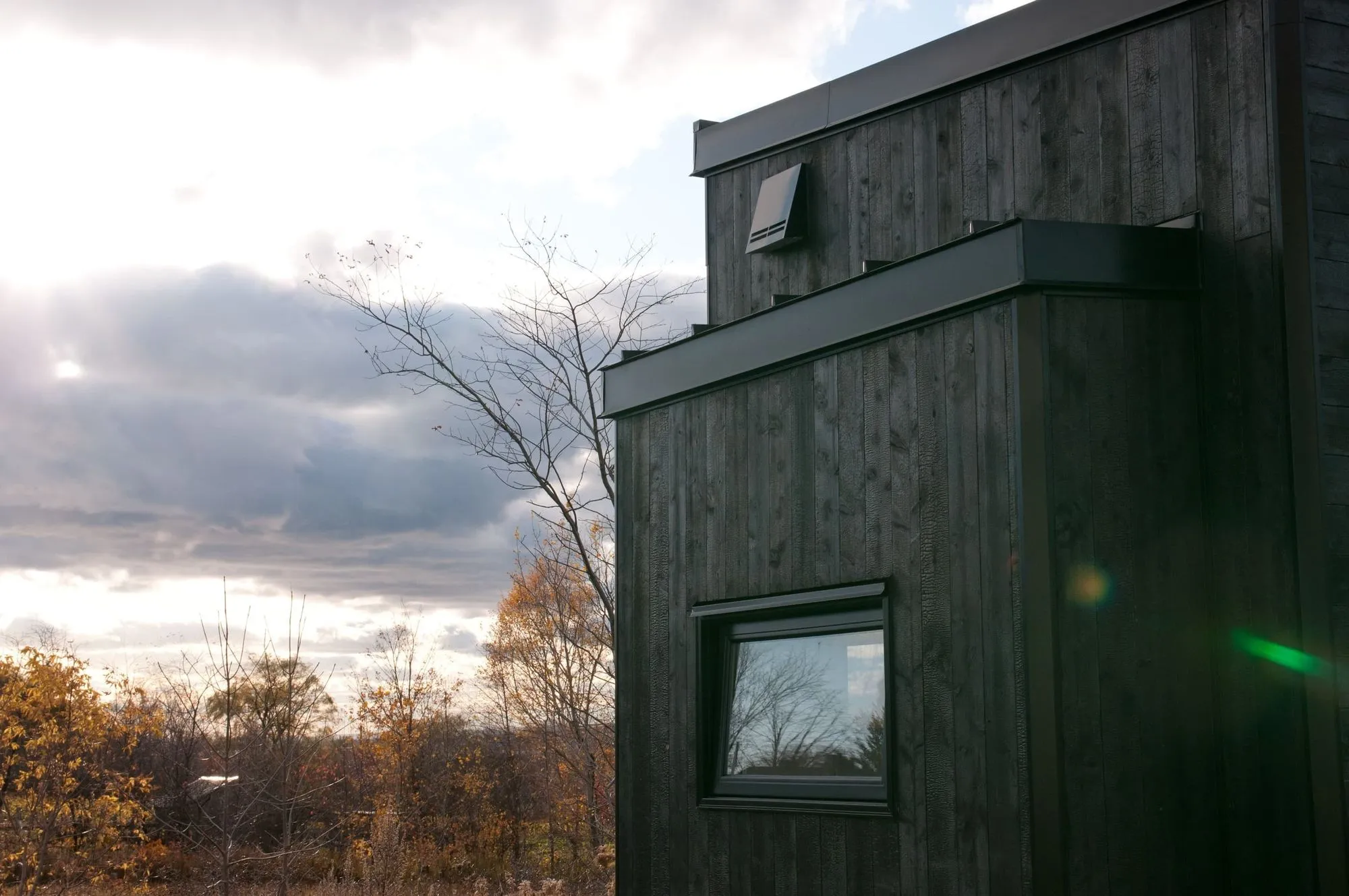 Tiny Home black with dark wood in fall