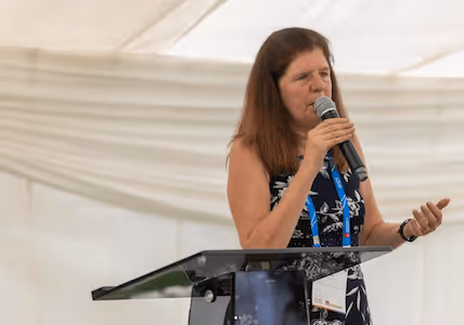 Rebecca speaking into a microphone