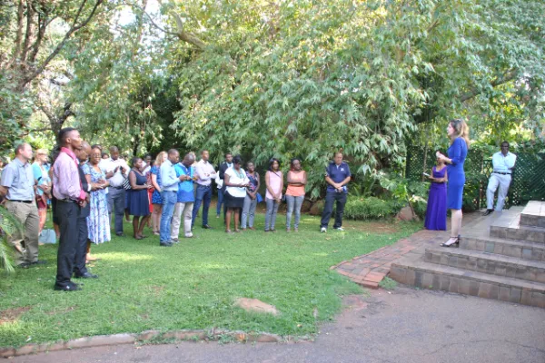 Students and community members gather attentively outdoors at Education Matters school in Zimbabwe campus