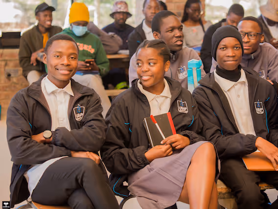 Happy students in uniform at Education Matters school in Zimbabwe, Africa smiling together.