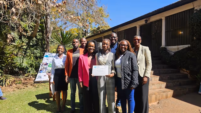 Students and teachers celebrate at Education Matters school in Zimbabwe, Africa, with certificates.