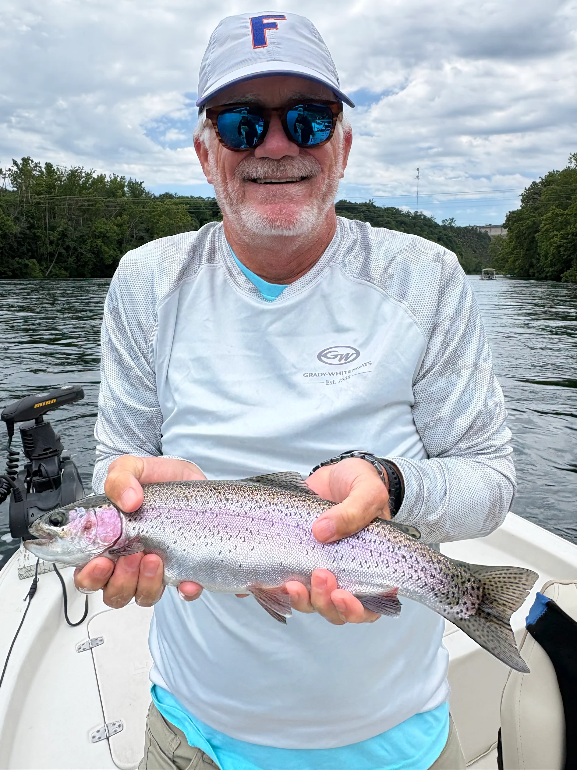 Lake Taneycomo angler holding a rainbow trout on a guided fishing trip