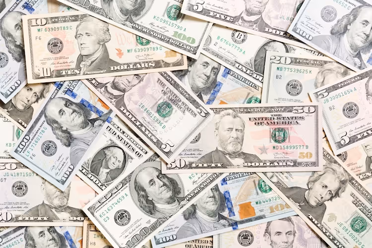 Scattered US dollar bills of various denominations spread across background