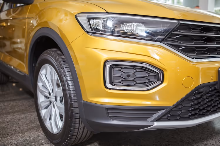 Yellow SUV front side view with detailed headlight and wheel design