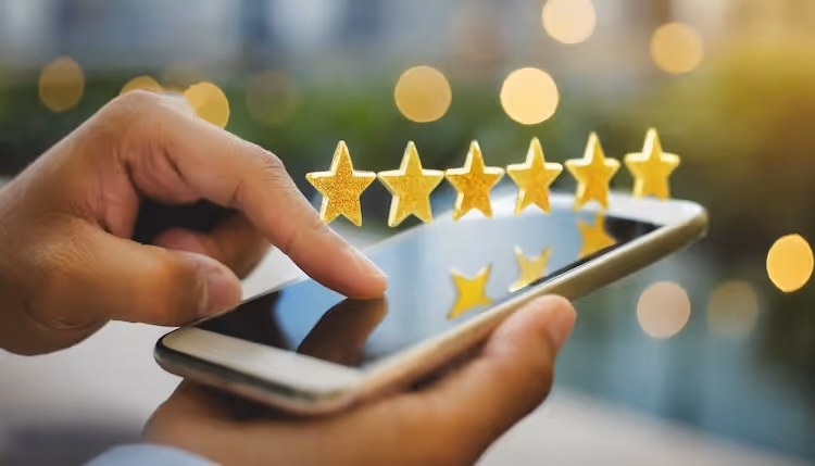 Hand touching smartphone screen with five golden stars for online rating