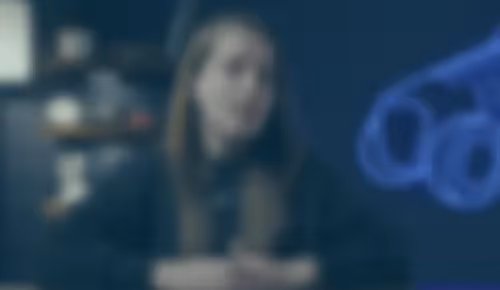 Blurred figure sitting in dark room with blue light in background