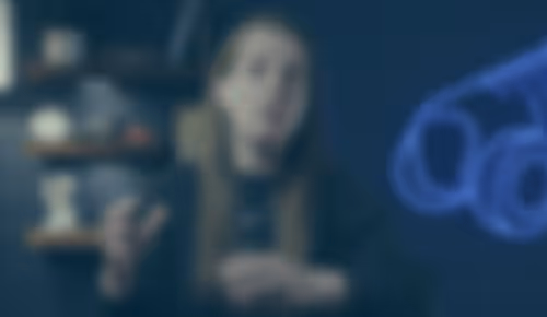 Blurry person sitting in dimly lit room with blue light effect