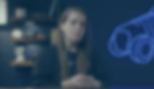 Person sitting in dimly lit room with blurred background