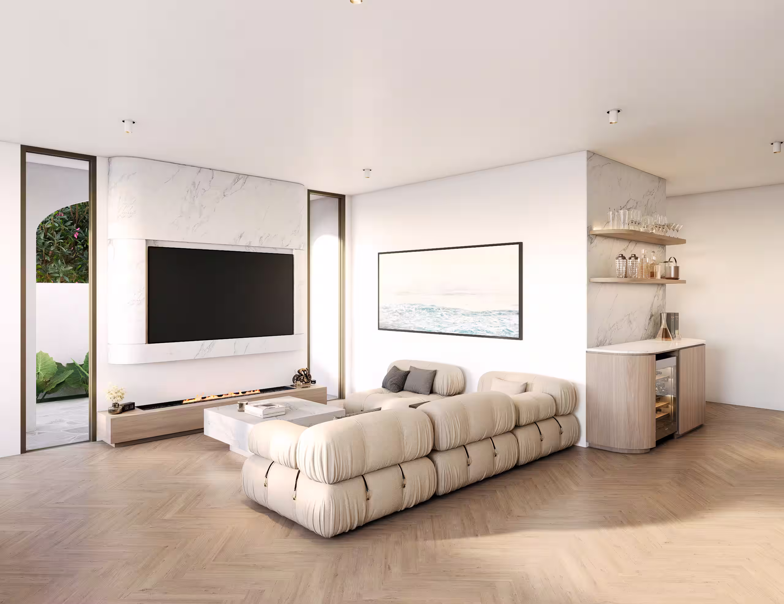 Modern living room with a beige L-shaped sofa, marble coffee table, wall-mounted TV above a gas fireplace, framed ocean art, and a wooden bar area with shelves and glassware.