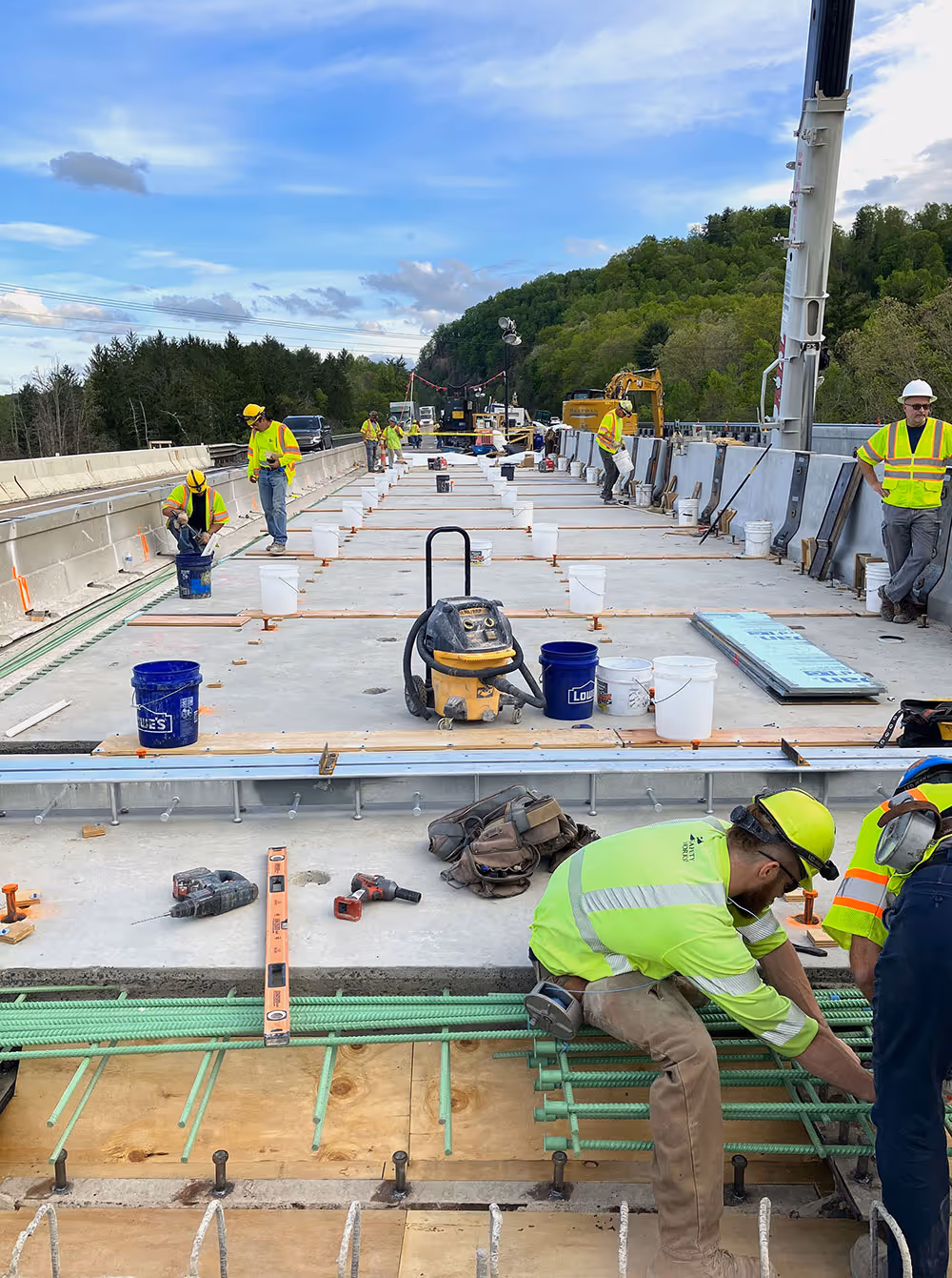 men working on bridge with precast concrete