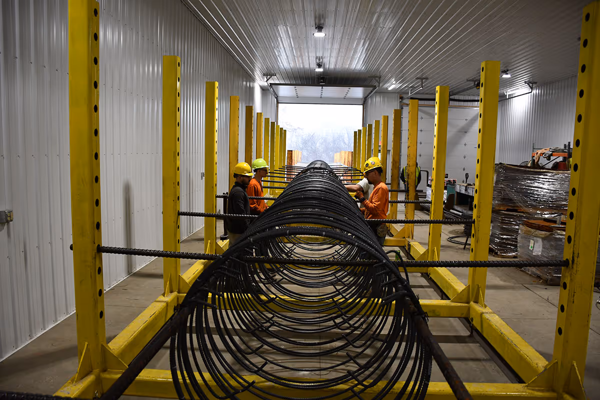 Workers collaborating on a prebuilt reinforcing bar project