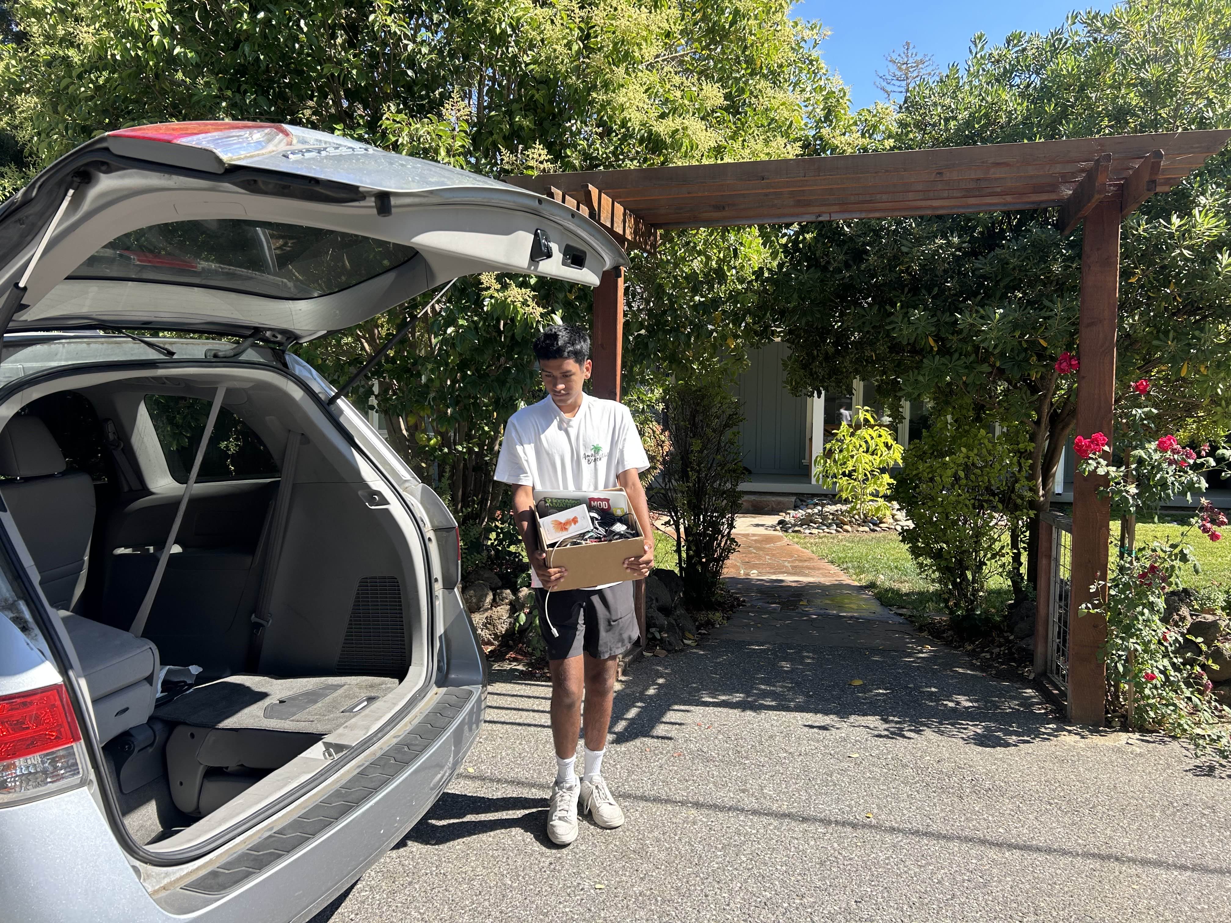 Tech for Tomorrow co-founder loading tech from a local pick-up into a van