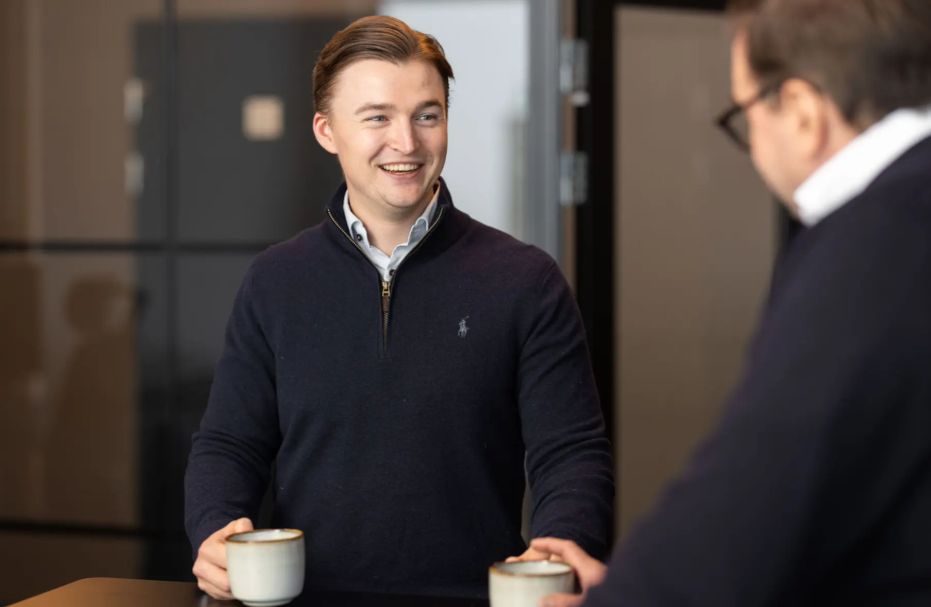 Kvinne smiler i sammen med en kollega